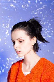 beautiful girl in an orange sweater on a blue background. High quality photo