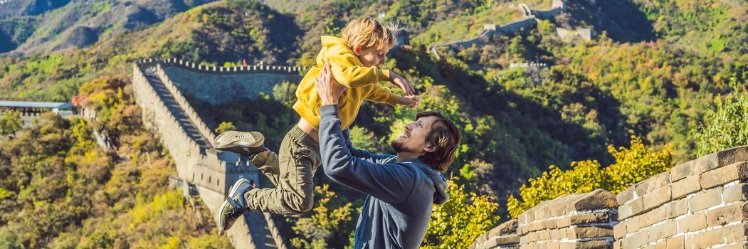Happy cheerful joyful tourists dad and son at Great Wall of China having fun on travel smiling laughing and dancing during vacation trip in Asia. Chinese destination. Travel with children in China concept. BANNER, LONG FORMAT