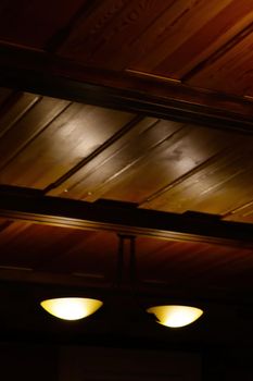 Blurry background, out of focus. Wooden ceiling with lamp, out of focus