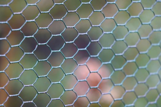 Close-up on a mesh fence or fencing. Out of focus