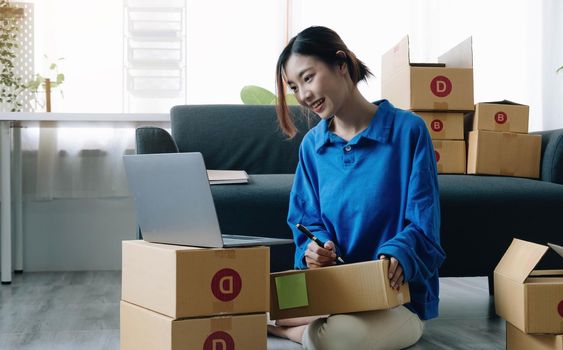 Portrait of Asian young woman SME working with a box at home the workplace.start-up small business owner, small business entrepreneur SME or freelance business online and delivery concept..