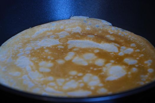 Cooking a pancake in a frying pan at home