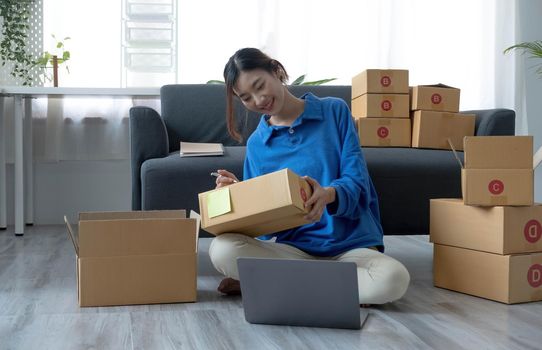 Portrait of Starting small businesses SME owners female entrepreneurs working on receipt box and check online orders to prepare to pack the boxes, sell to customers, sme business ideas online..