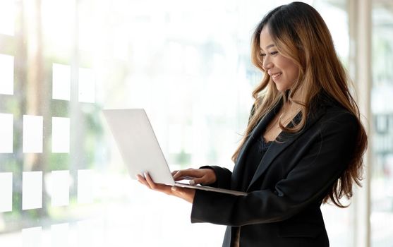 Young Asian business woman working online on a laptop in office..