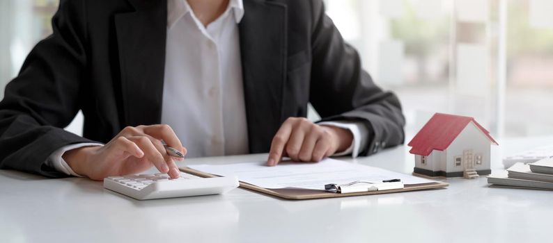 Businesswoman doing finances and calculate about cost to real estate investment.