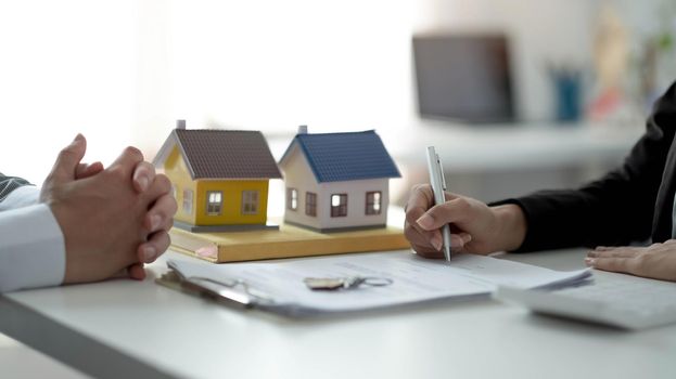 Real estate agent or sales manager has proposed terms and conditions to customers who sign house purchase agreements with insurance, Agreement to sign the purchase contract concept..