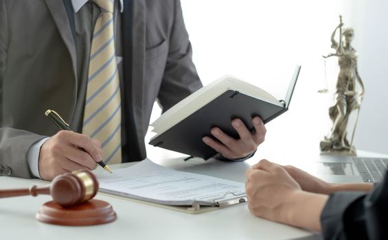 Business woman and lawyers discussing contract papers with brass scale on wooden desk in office. Law, legal services, advice, Justice concept..