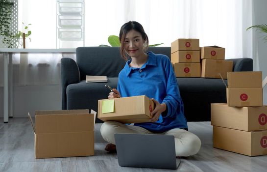 Portrait of Starting small businesses SME owners female entrepreneurs working on receipt box and check online orders to prepare to pack the boxes, sell to customers, sme business ideas online..