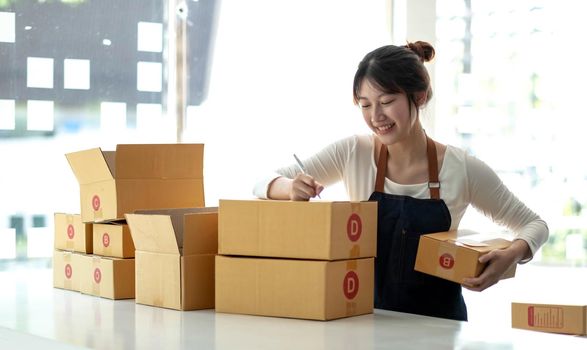 Portrait of Starting small businesses SME owners female entrepreneurs working on receipt box and check online orders to prepare to pack the boxes, sell to customers, sme business ideas online..