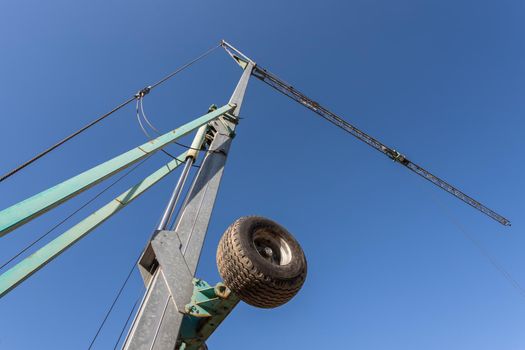 Photos of a construction crane against the blue sky. Bottom view.