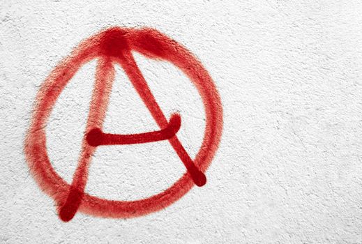 Red anarchy symbol on wall. Ideal for textures, backgrounds and concepts. Copy space.