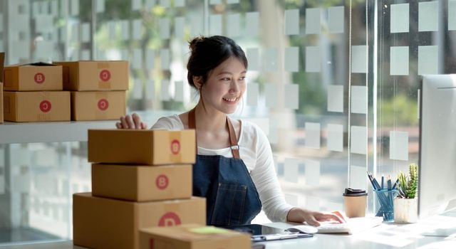 Starting small businesses SME owners female entrepreneurs Live chatting with customers to receive and review online orders to prepare pack boxes, shopping online delivery, SME business ideas online..