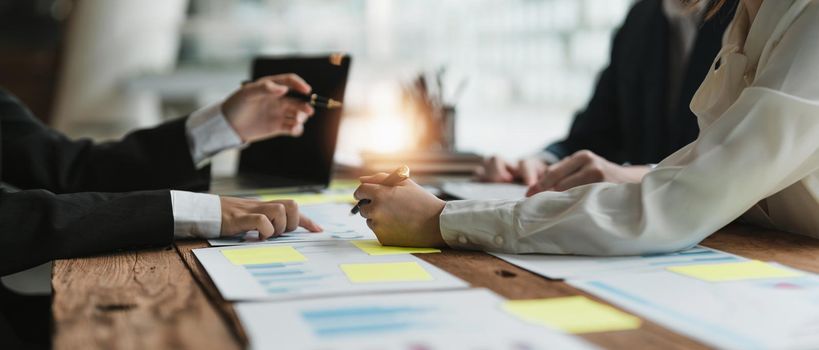 Business People Meeting using laptop computer,calculator,notebook,stock market chart paper for analysis Plans to improve quality next month. Conference Discussion Corporate Concept.