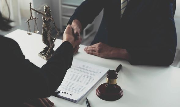 Businessman shaking hands to seal a deal with his partner lawyers or attorneys discussing a contract agreement..