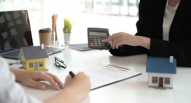 Real Estate Agent broker or House developer showing contract for buying house agreement to consultant employee.