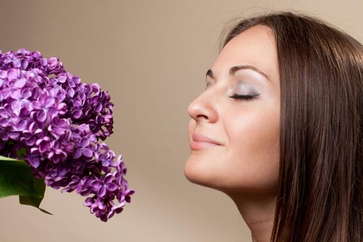 Beautiful young girl weared in black dress with a bouquet of lilac. Spring flowers concept.