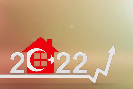 The cost of real estate in Turkey in 2022. Rising cost of construction, insurance, rent in Turkey. 3d House model painted in flag colors, up arrow on yellow background.