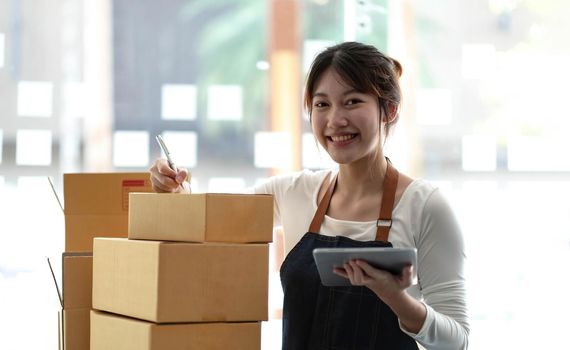 Portrait of Starting small businesses SME owners female entrepreneurs working on receipt box and check online orders to prepare to pack the boxes, sell to customers, sme business ideas online..