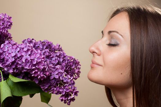 Beautiful young girl weared in black dress with a bouquet of lilac. Spring flowers concept.