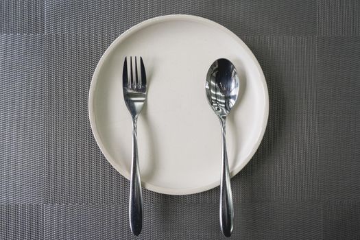 empty plate spoon and fork on table in restaurant.