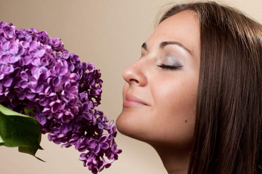 Beautiful young girl weared in black dress with a bouquet of lilac. Spring flowers concept.