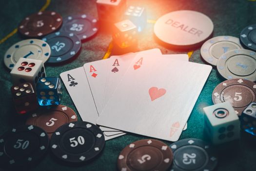 close-up playing chips and playing cards. casino poker game concept. Playing cards, poker chips, and dices on green table. the view from the top