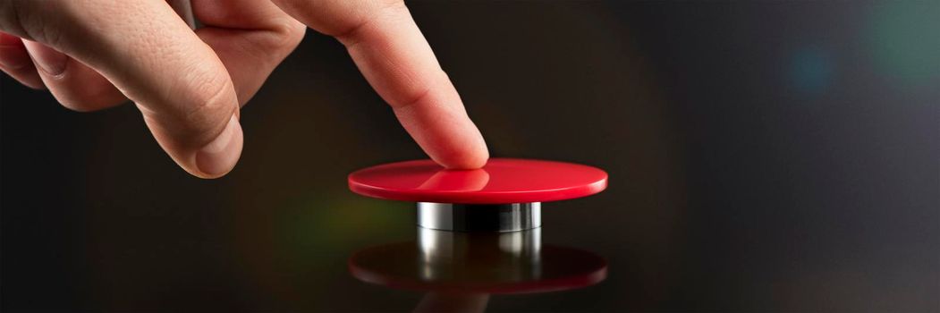 A man's hand presses a big red button. Red button on a dark background. The threat of using nuclear or chemical weapons of mass destruction. Rocket launch at the push of a button.