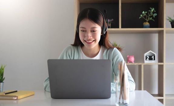 Smart asian young girl student feel satisfied during internet online video conference and searching information via laptop computer at home.