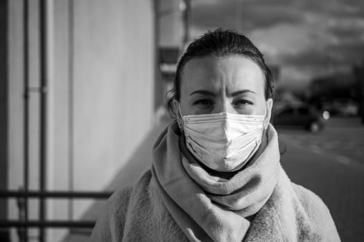 A picture of a girl in a mask. On the street. isolated Covid-19 pandemic.