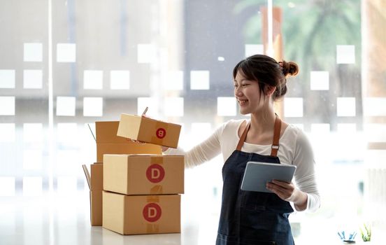 Portrait of Starting small businesses SME owners female entrepreneurs working on receipt box and check online orders to prepare to pack the boxes, sell to customers, sme business ideas online..