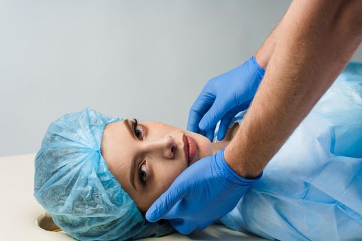 Consultation with plastic surgeon on white background. Cosmetic rejuvenating facial treatment.