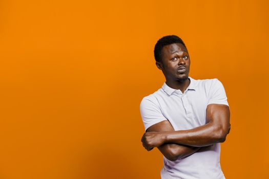 Big discount for our customers. Funny black man points right side and grimacing on orange background. Smiley people lifestyle.