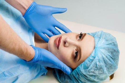 Consultation with plastic surgeon on white background. Cosmetic rejuvenating facial treatment.