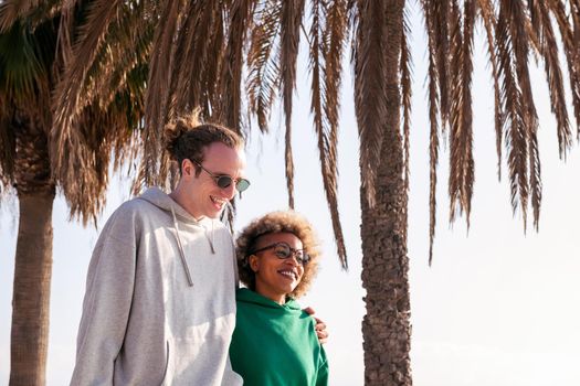 young interracial couple smiling and having a good time while strolling, concept of friendship and fun in a relationship