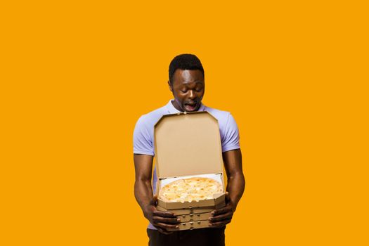 Handsome african bearded courier with 4 pizza boxes. Tasty food pizza delivery from restaurant. Safety delivery. Pizza with cheese boards advert.