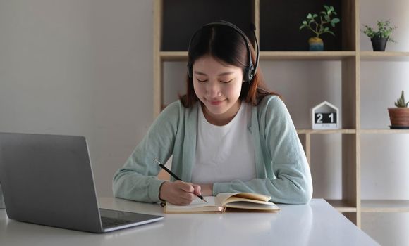 Asian woman student video conference e-learning with teacher on computer in living room at home. E-learning ,online ,education and internet social distancing protect from COVID-19 viruses..