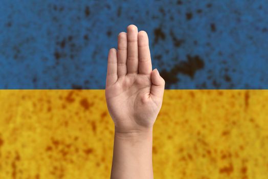 Support for Ukraine and solidarity. Children's hands on the background of the Ukrainian flag. The concept of confrontation and struggle.