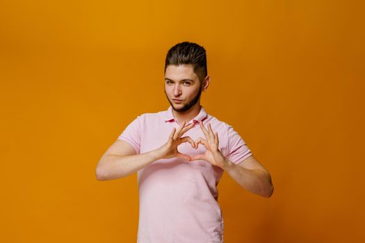 Attractive caucasian man feels thankful. Thanking for help. Advertise for psychology agency. Handsome young student shows heart in his hands.