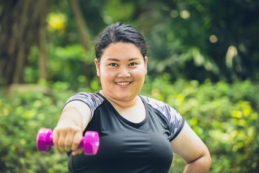 fat girl happy smile with dumbbell sport outdoor exercise for healthy and diet