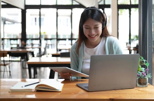 Asian woman student video conference e-learning with teacher on computer in living room at home. E-learning ,online ,education and internet social distancing protect from COVID-19 viruses..