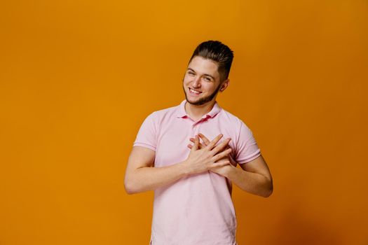 Attractive caucasian man feels grateful. Thanking for help. Advertise for psychology agency. Handsome young student touches his heart.