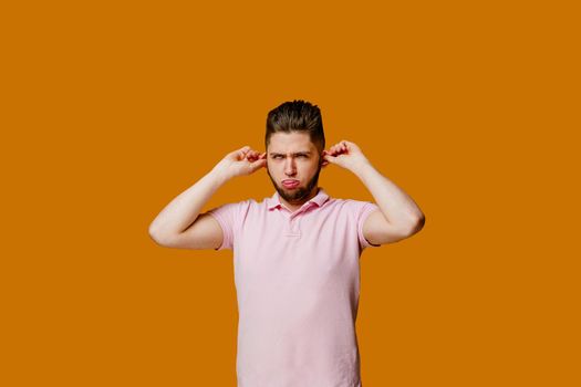 Funny handsome man fools around and makes crazy emotions. Caucasian man wears pink t-shirt. Online work at home quarantine concept