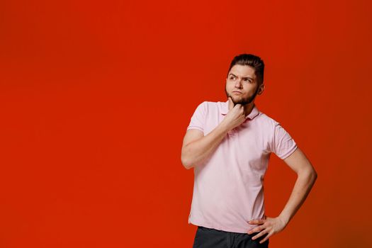Funny handsome man fools around. Thinking and making crazy emotions. Caucasian man touches his beard and thinks. On-line work at home