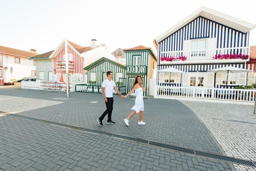 Love story of couple have dating and looks each others in Aveiro, Portugal near colourful and peaceful houses. Lifestyle. Having fun, laughs, smiles