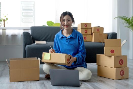 Portrait of Starting small businesses SME owners female entrepreneurs working on receipt box and check online orders to prepare to pack the boxes, sell to customers, sme business ideas online..