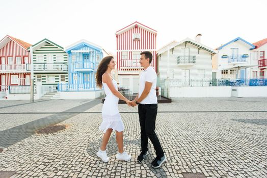 Love story of couple have dating and looks each others in Aveiro, Portugal near colourful and peaceful houses. Lifestyle. Having fun, laughs, smiles.