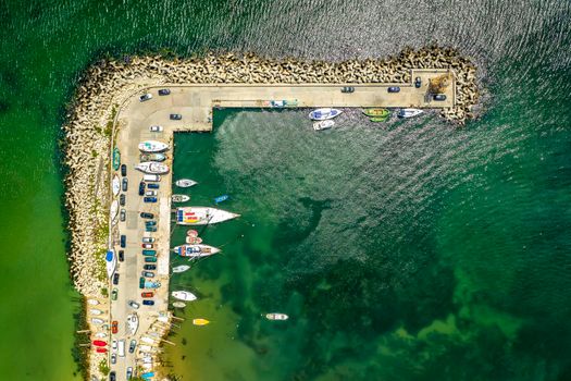 Aerial view of the marina with boats and yachts. The transparent sea with white yachts from above
