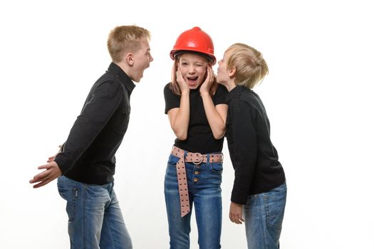 Two boys are shouting at a girl, the girl is standing in a helmet in a hard hat and plugged her ears, isolated on a white background