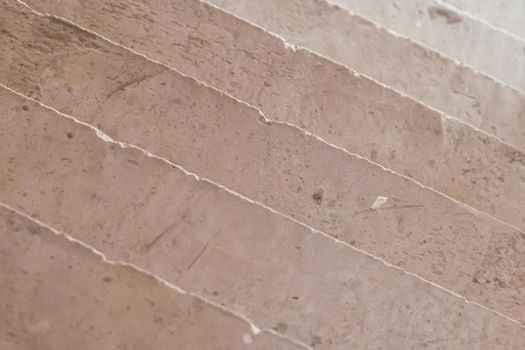 Abstract real photo background. Diagonal lines. View from above concrete stairs like ceramic stoneware tiles wall, pattern with irregular veins material texture decor design. Light brown beige khaki.