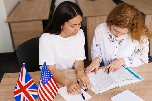 Foreign school private study, smile, laught with a school girl. Teacher explain grammar of native language using laptop. Prepearing to exam with tutor.